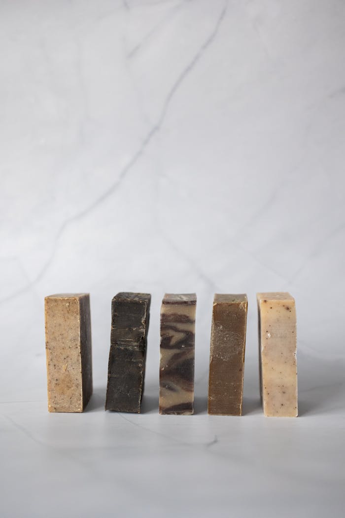 Set of handmade organic soaps placed in row against light marble background in studio